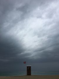 Scenic view of beach against cloudy sky