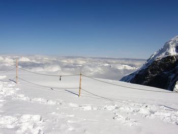 Scenic view of snowcapped mountains against clear blue sky