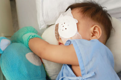 Cute boy with bandage on eyes sleeping in hospital