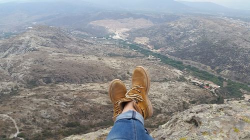 Low section of person sitting against landscape