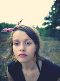 Portrait of girl on field against clear sky