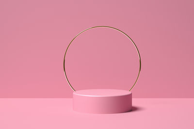 3d render podium for cosmetic products of pink color with a ring of gold color