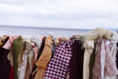 Close-up of clothes drying against sky over sea
