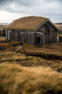 Abandoned house on field against sky