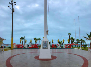 Street light and palm trees against sky