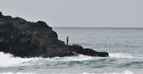 Man standing by sea against clear sky