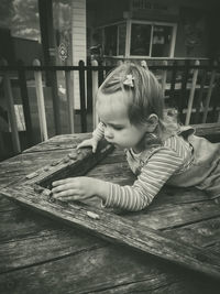 Side view of boy sitting on table