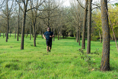 Full length of man with bare trees in forest