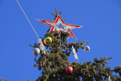 Low angle view of christmas tree against clear blue sky