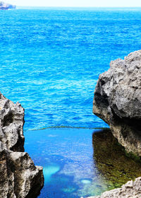 High angle view of rock formation in sea against sky