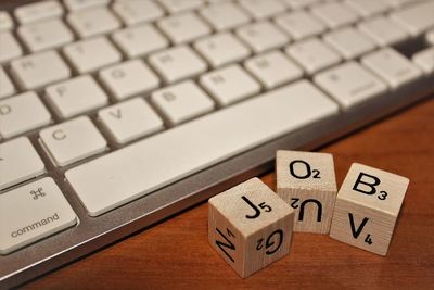 Close-up of alphabet blocks and computer keyboard on table