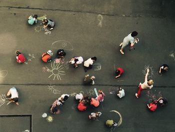 Directly above shot of children drawing on playground