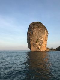 Rock formation in sea against sky