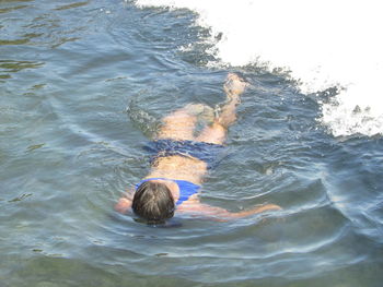 Low section of man swimming in sea