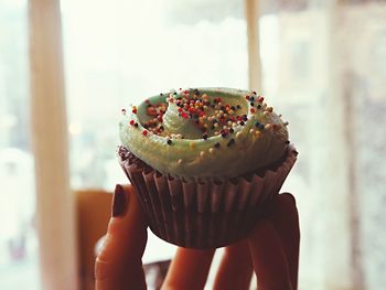 Close-up of hand holding cupcake