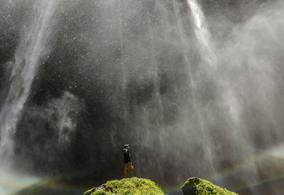 Man looking at waterfall