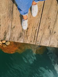 Low section of person standing on swimming pool