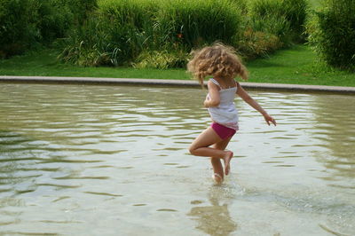 Rear view of girl jumping in water