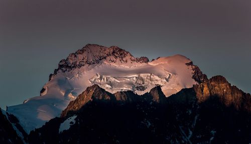 Scenic view of snowcapped mountains against sky during sunset