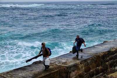 Full length of man fishing at sea shore