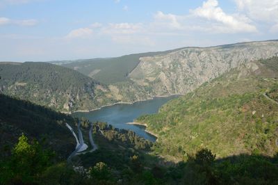 Scenic view of river amidst mountains against sky