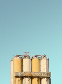 Low angle view of factory against blue sky