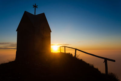 Low angle view of silhouette tower against sky during sunset