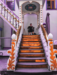 Rear view of woman standing on staircase in building