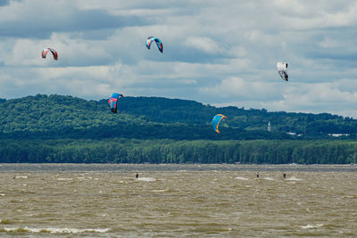 People flying over sea against sky