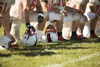 Low section of football team kneeling on playing field