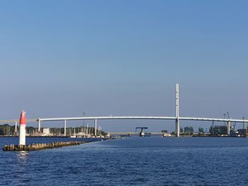 Bridge over sea against clear sky