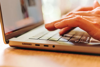 Cropped hand using laptop on table