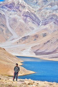 Full length of man standing by lake against mountains