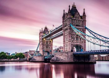 Tower bridge over river against sky during sunset