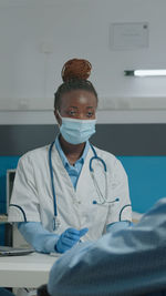 Portrait of female doctor examining chemical at clinic