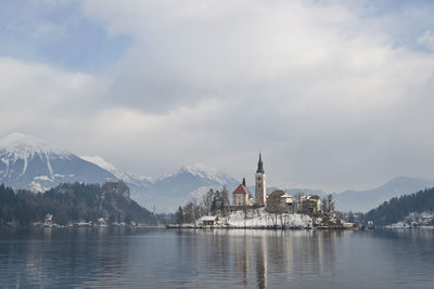 River by church and snowcapped mountains against sky