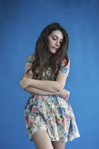 Portrait of a beautiful young woman against blue background