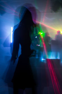 Blurred motion of woman standing at night