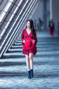 Asian woman walking in the street with modern architectural background