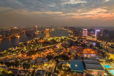 High angle view of illuminated city against sky at night