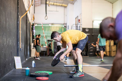 Athlete adjusting weights on barbells