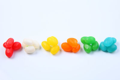 Close-up of multi colored candies against white background