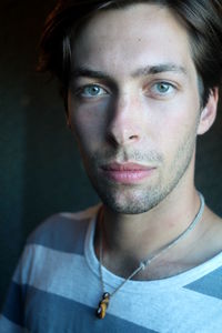 Close-up portrait of young man standing against wall