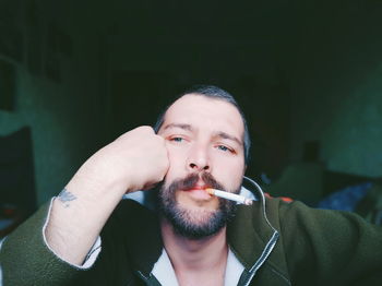 Portrait of young man smoking cigarette outdoors