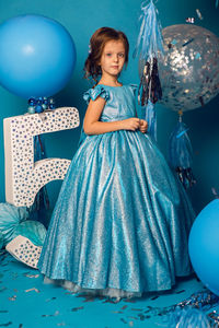 Girl in the blue dress in the studio with the balloon and with the number five