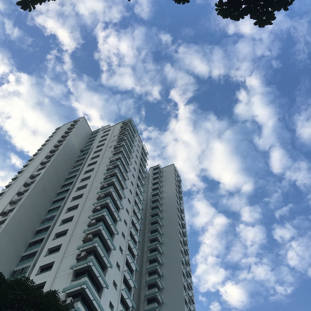 low angle view, sky, architecture, built structure, building exterior, cloud - sky, cloud, cloudy, pattern, famous place, day, outdoors, travel destinations, repetition, no people, architectural feature, modern, in a row, tall - high, city