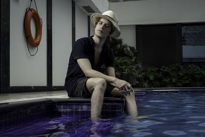 Full length of woman sitting in swimming pool