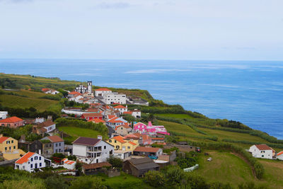 High angle view of buildings by sea against sky