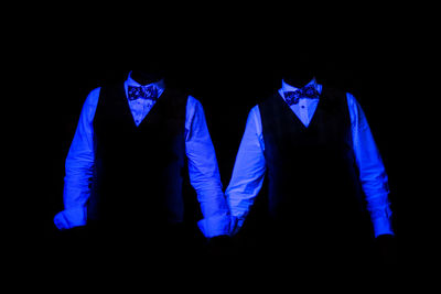 Low angle view of illuminated lighting equipment against black background