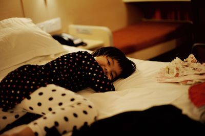 Smiling girl lying on bed at home